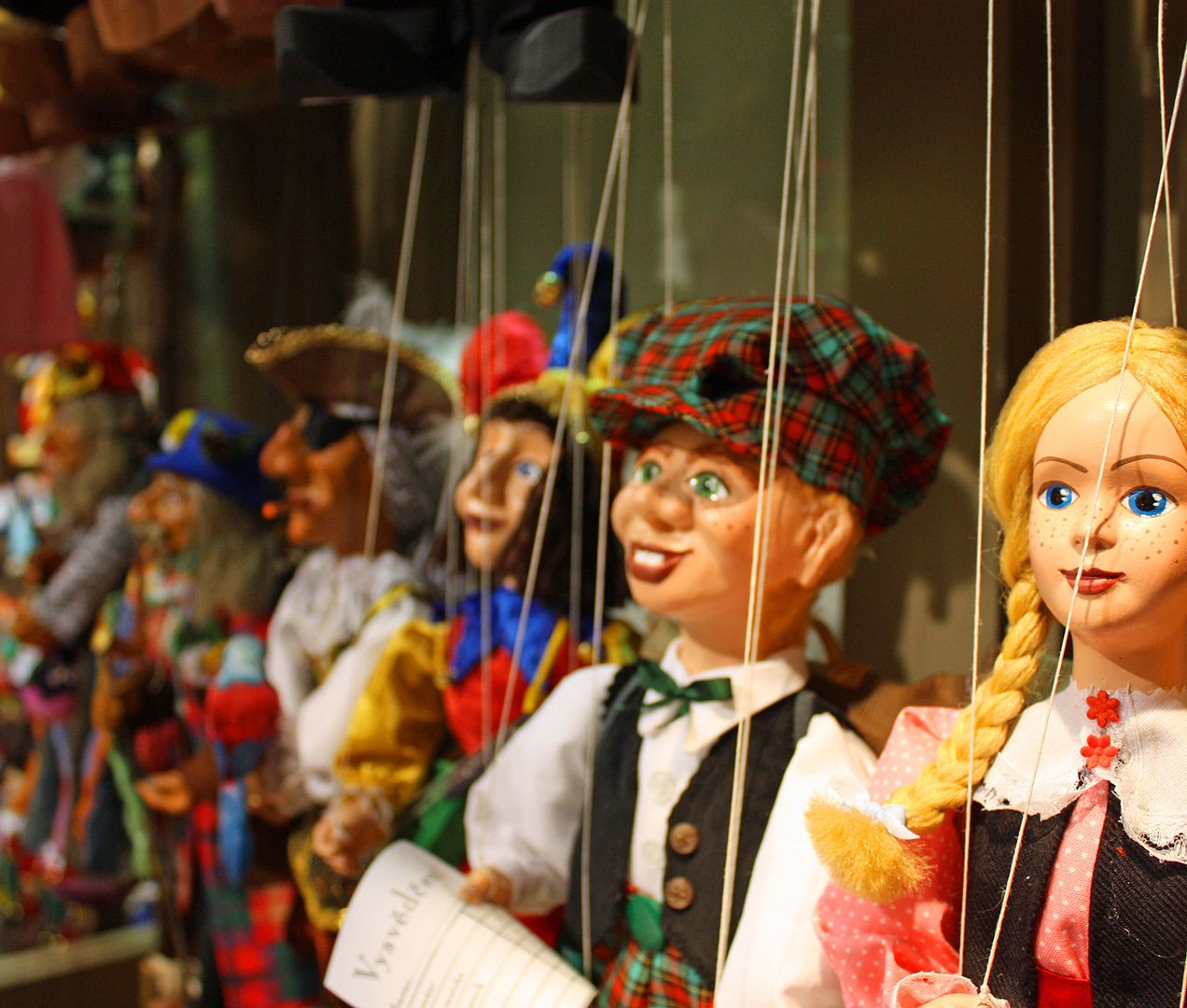 Mehrere Puppen hängen an Fäden und bilden eine lebendige Szene, die die Kunst des Puppenspiels verkörpert.